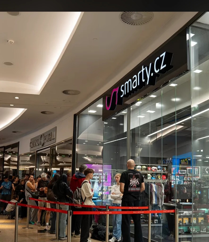 Zákazníci čekající ve vyhrazené frontě u vstupu do prodejny Smarty.cz
